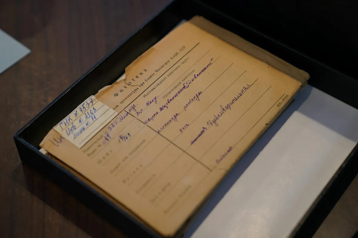 A handwritten 1920s museum accession label, slightly yellowed, photographed in warm light