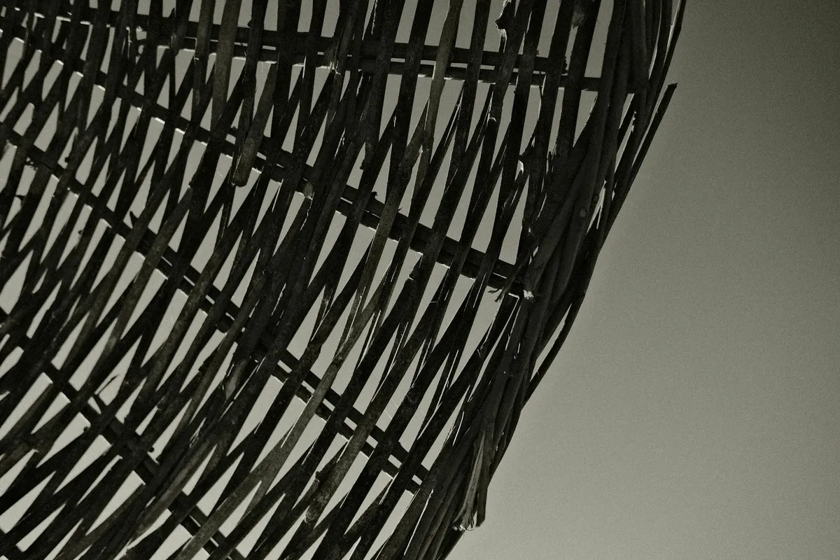 Close-up of a hand-woven basket showing weft, warp, and stitching technique